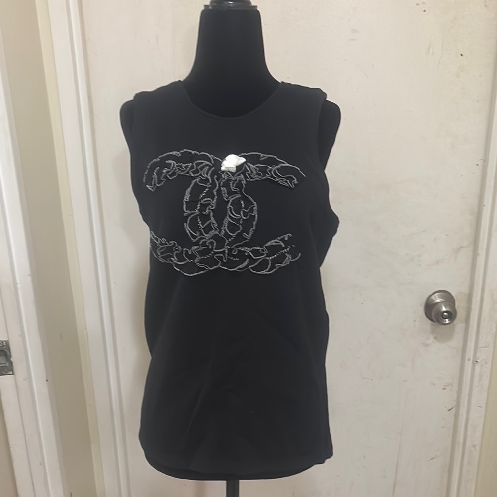 Gently worn Chanel Black Sleeveless Top with a Chanel logo and a white Camille